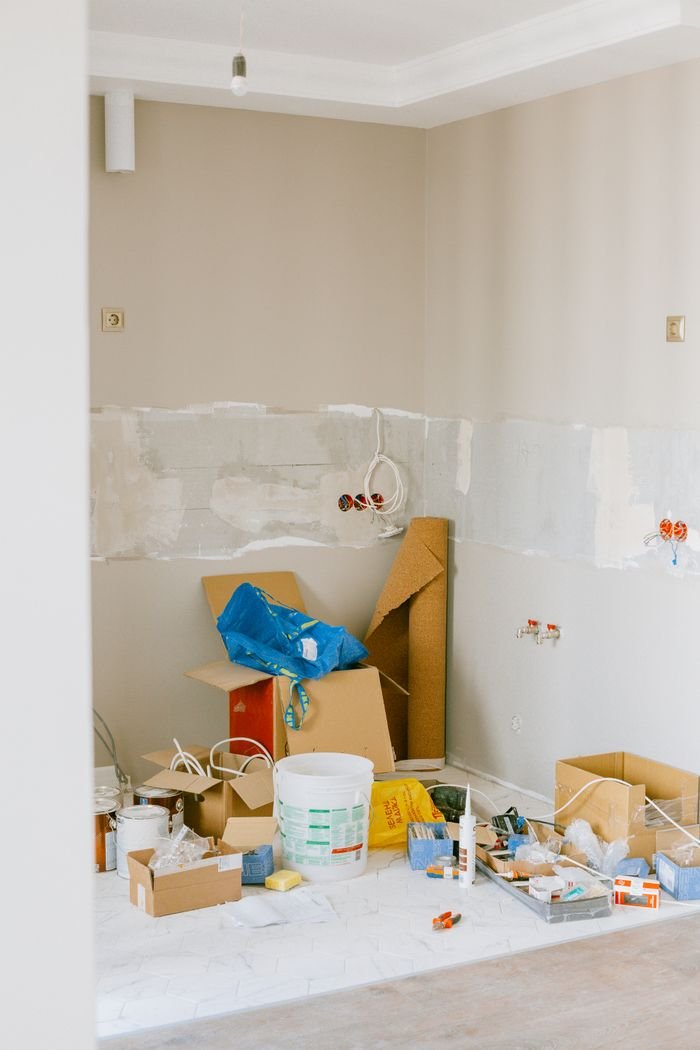 A room in the midst of home renovation with tools and supplies scattered around.